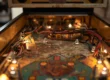 Interior de uma máquina de pinball clássica sendo restaurada, mostrando componentes eletrônicos e cabos em um gabinete de madeira.